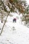 Young man in warm hat and child girl and boy on rural winter snowy background holding umbrella. Happy family, cold