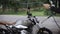 Young man washing his scrambler motorbike with water hose on the street