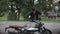 Young man washing his scrambler motorbike with water hose on the street