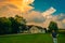 A young man watches as storm clouds rise over a midwest home in the country.