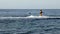 A young man water skiing on a sea. Waterskier moving fast in splashes of water. Man wakeboarding on a sea.