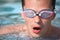 Young man in watersport goggles swimming in pool