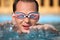 Young man in watersport goggles swimming in pool