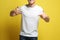 Young man wearing blank t-shirt on yellow background, closeup. Mockup for