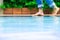 Young man wearing blue Jean walking alone at the edge of the swimming pool.