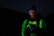 Young man wearing hiking equipment using cellphone at night