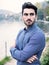 Young man wearing beside picturesque river or lake