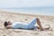 Young man wearing sunglasses while sunbathing at the beach