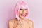 Young man wearing woman make up wearing pink wig doing happy thumbs up gesture with hand