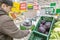 A young man weighs goods on an electronic self-service scale in the vegetable department of a chain hypermarket.