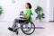 Young man in wheel-chair doing exercises indoors