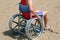 Young man on the wheelchair on the beach