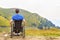 Young man in a wheelchair enjoying fresh air in a sunny day