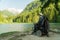 Young man in a wheelchair fishing at the beautiful lake on a sunny day, with mountains in the back