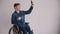 Young man in wheelchair making selfie. disabled adult guy taking photo of himself