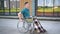 Young man in a wheelchair. A man rides in a wheelchair against the background of a glass building. Special transport for