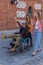 Young man in a wheelchair next to two happy young girls walking down the street