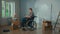 A young man in a wheelchair is planning repairs using a mobile phone. Disabled male browsing interior design ideas on