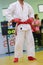 Young man in white kimono for sambo, judo, jujitsu posing on white background, looking straight, position of fighting post, hands