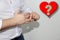 Young man in a white shirt expressively removes a gold wedding ring from his thumb, concept of marital quarrel, divorce