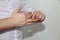 Young man in a white shirt expressively removes a gold wedding ring from his thumb, concept of marital quarrel, divorce