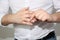 Young man in a white shirt expressively removes a gold wedding ring from his thumb, concept of marital quarrel, divorce