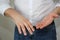 Young man in a white shirt holds in his hand a shot of a golden wedding ring, concept of marital quarrel, divorce, betrayal