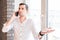 Young man in white shirt speaking over phone with interrogative expression