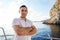 Young man in white shirt standing on the nose yacht in the sea