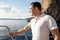 Young man in white shirt standing on the nose yacht in the sea