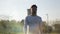 Young man in white sweater walking in city park