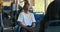 A young man in a white T-shirt sits on a public transport bus in front