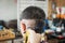 Young man who have gray hair being haircut with electric clipper machine by professional barber in barbershop