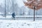 Young man in the winter clothes riding a bicycle on the cold snowy day.