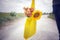 Young man or woman with bouquet of flowers in yellow eco bag on natural light  in the rural white  coral road view background