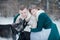 Young man and woman covering with green wool blanket playing with Siberian husky