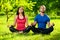 Young man and woman doing yoga in the sunny summer