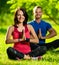 Young man and woman doing yoga in the sunny summer