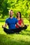 Young man and woman doing yoga in the sunny summer park