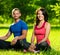 Young man and woman doing yoga in the sunny summer park