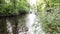 Young man and woman floating on a river on a water bike among green trees