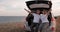 Young Man and Woman Having Fun on Road Trip, Sitting in the Openned Trunk of Their Suv Car with Sea View at the Edge of