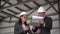 Young man and woman in helmets with documents at a construction site. Businessmen in suits conclude an agreement. A man