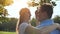 A young man and woman are hugging in a park on a summer day.