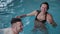Young man and woman joking and smiling in the pool.