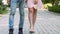 Young man and woman legs walking on park path, holding hands, romantic date