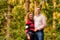 A young man and woman in love are standing in the forest. The couple stands with their arms around each other