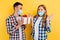 Young man and a woman in plaid shirts and medical protective masks, a happy man gives a gift to his girlfriend, on an isolated