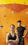 Young man and woman posing in climbing gym.