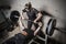Young man and woman powerlifting in a gritty basement gym